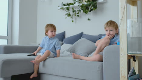 The-kids-are-watching-tv.-Small-children-sitting-on-the-couch-watching-cartoons